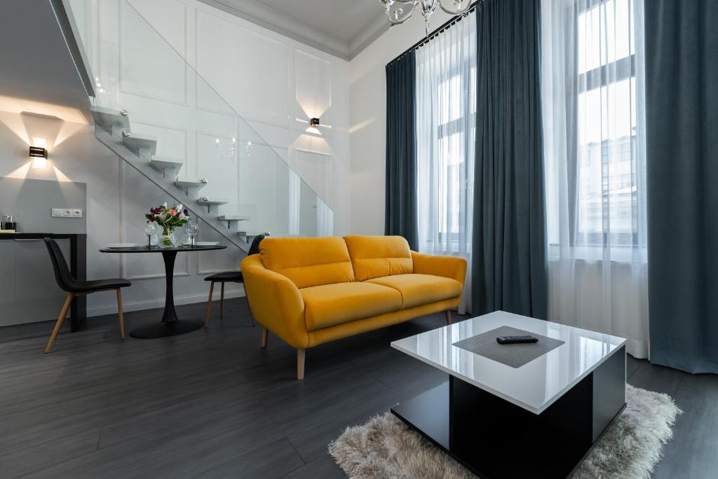 un soggiorno con divano giallo e tavolo di Apartamenty Centrum nowoczesny design - Dream Apart a Bielsko-Biała