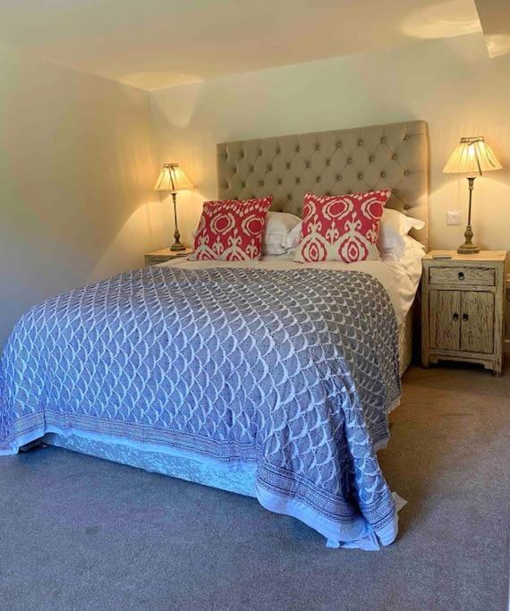 a bedroom with a large bed with red pillows at Little Innsacre in Bridport