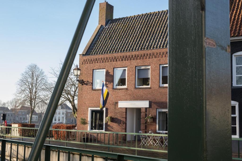 een bakstenen gebouw met een vlag ervoor bij Yep! Slapen bij de Sluis in Blokzijl