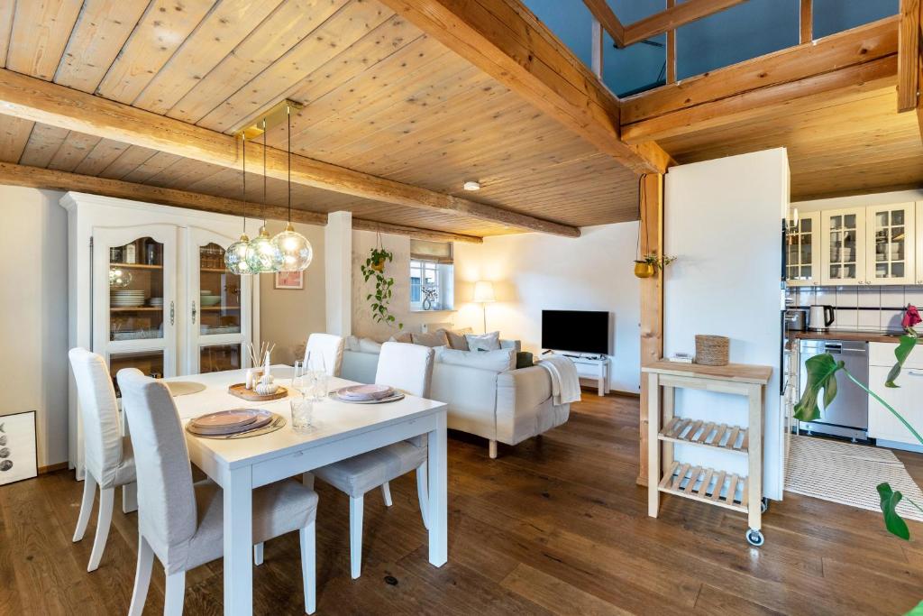 a dining room and living room with a table and chairs at Jules Reetdachkate in Mildstedt