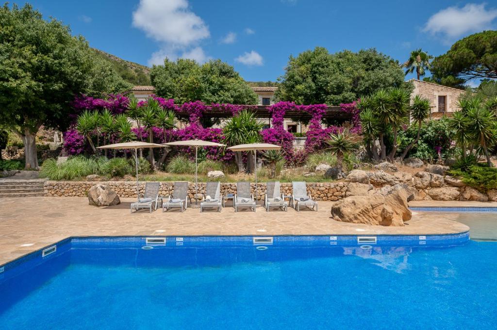 a swimming pool with lounge chairs and umbrellas at Agroturismo Son Siurana in Alcudia