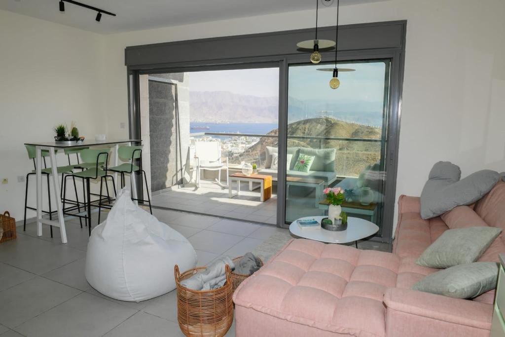a living room with a pink couch and a table at Gorgeous - Red rock and Sea view. in Eilat