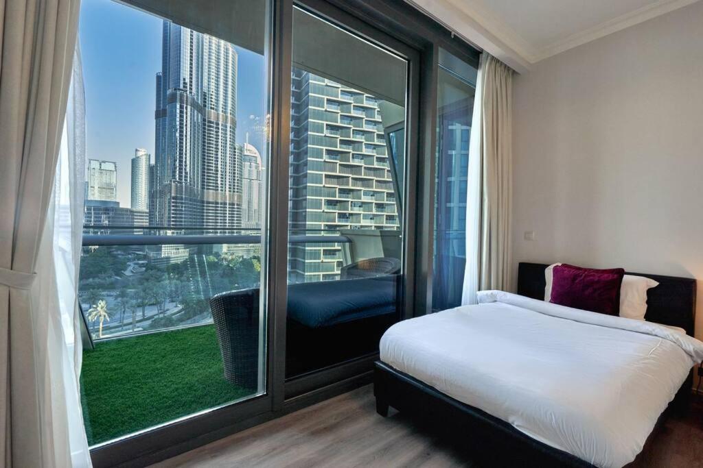 Schlafzimmer mit einem großen Fenster mit Stadtblick in der Unterkunft Magnificent Stunning 2 BR Apartment with Burj Khalifa View in Dubai