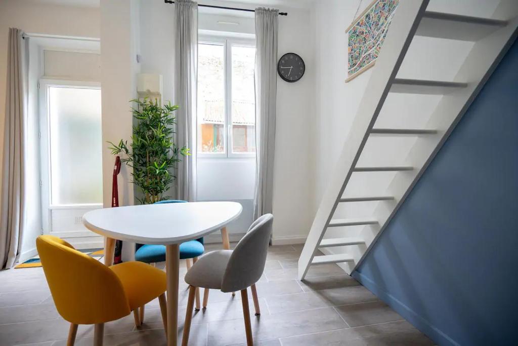 a dining room with a table and chairs and a staircase at Marechal's Studio near train station & downtown in Nantes