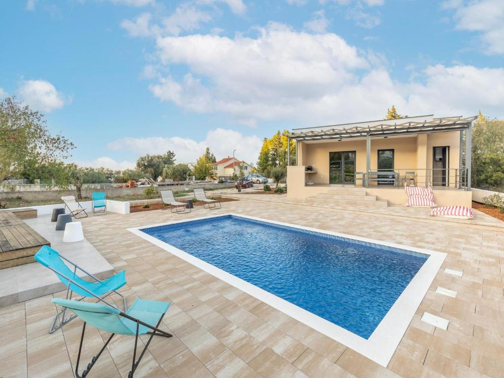 una piscina con sillas y una casa en Modern holiday home in Bilice with private pool en Bilice