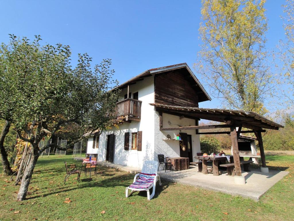 ein Haus mit einer Terrasse und einem Stuhl davor in der Unterkunft Secluded holiday home in Borgo Valbelluna with garden 