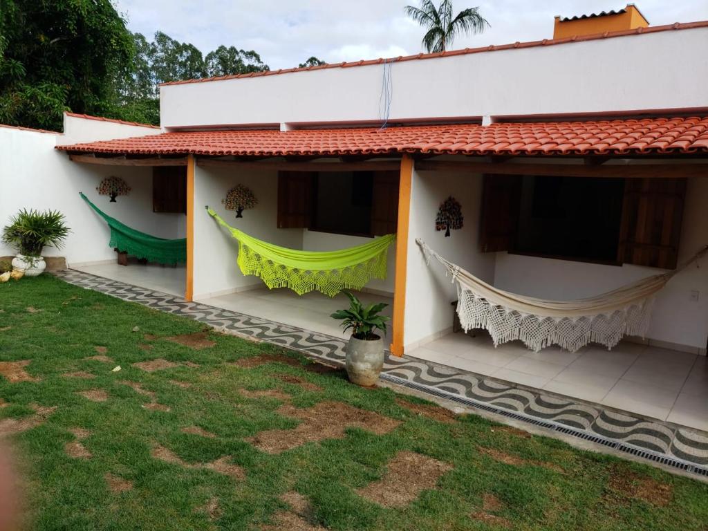 a house with hammocks on the side of it at POUSADA MANACÁ DA SERRA in Vargem Bonita