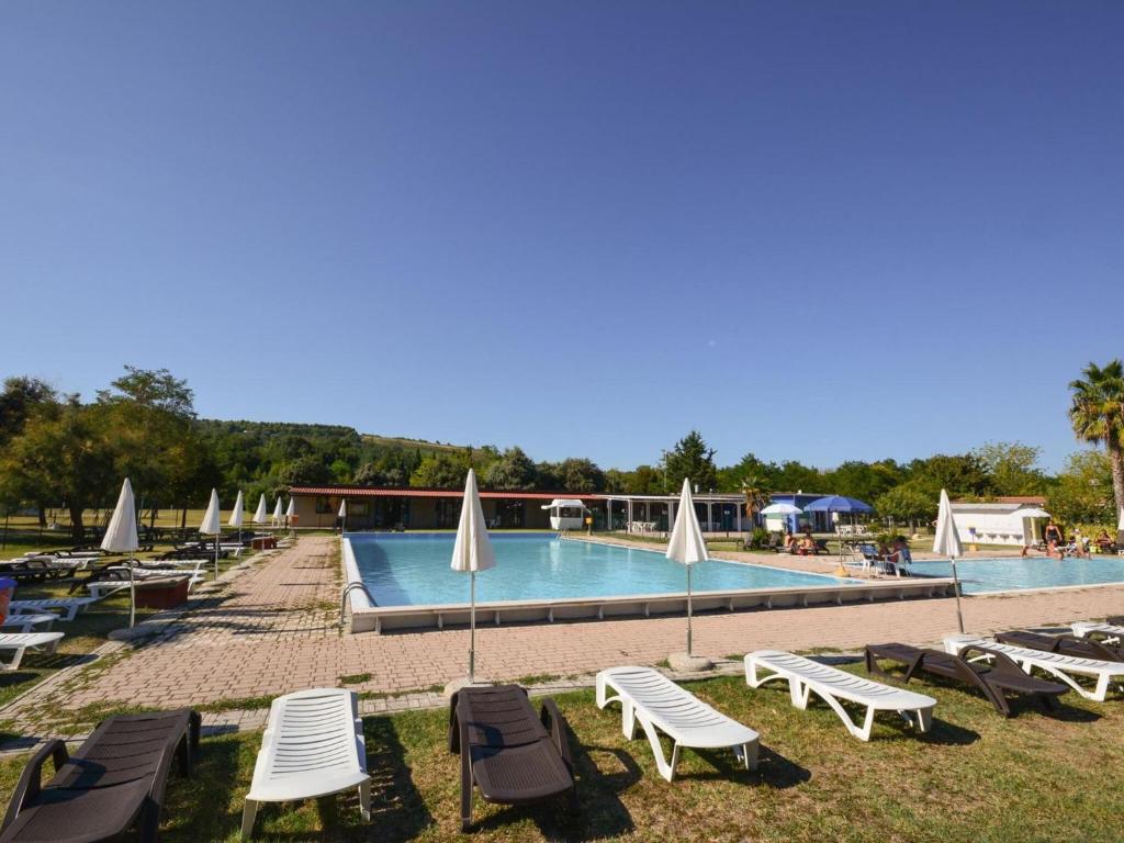 una piscina con sedie a sdraio e un gruppo di visiera di Inviting holiday home in Altidona with solarium a Pedaso