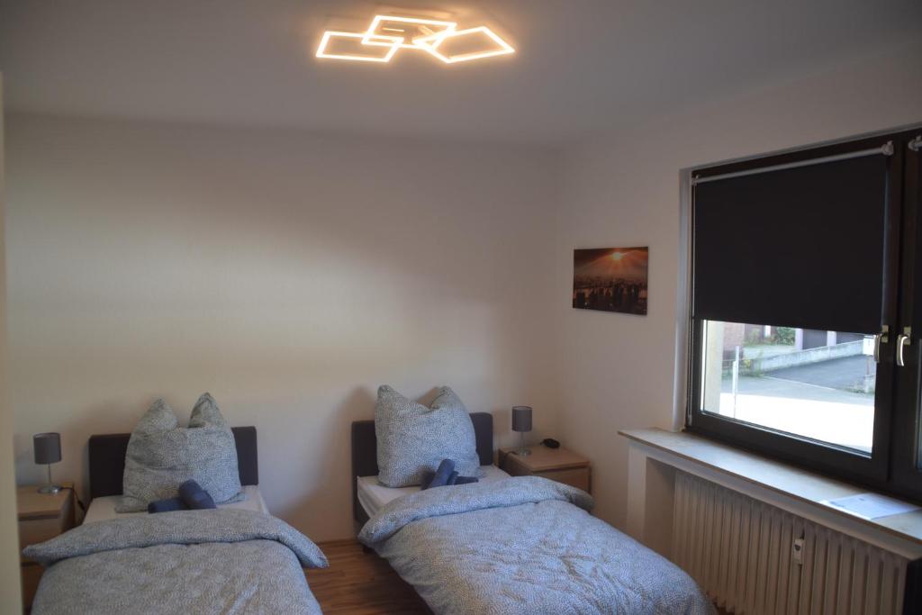 ein Schlafzimmer mit zwei Einzelbetten und einem Fenster in der Unterkunft Ruhrbetten in Gelsenkirchen