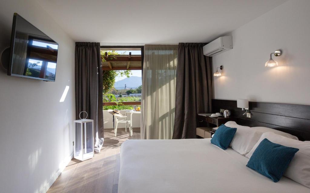 a hotel room with a bed and a balcony at Hôtel La Roya in Saint-Florent