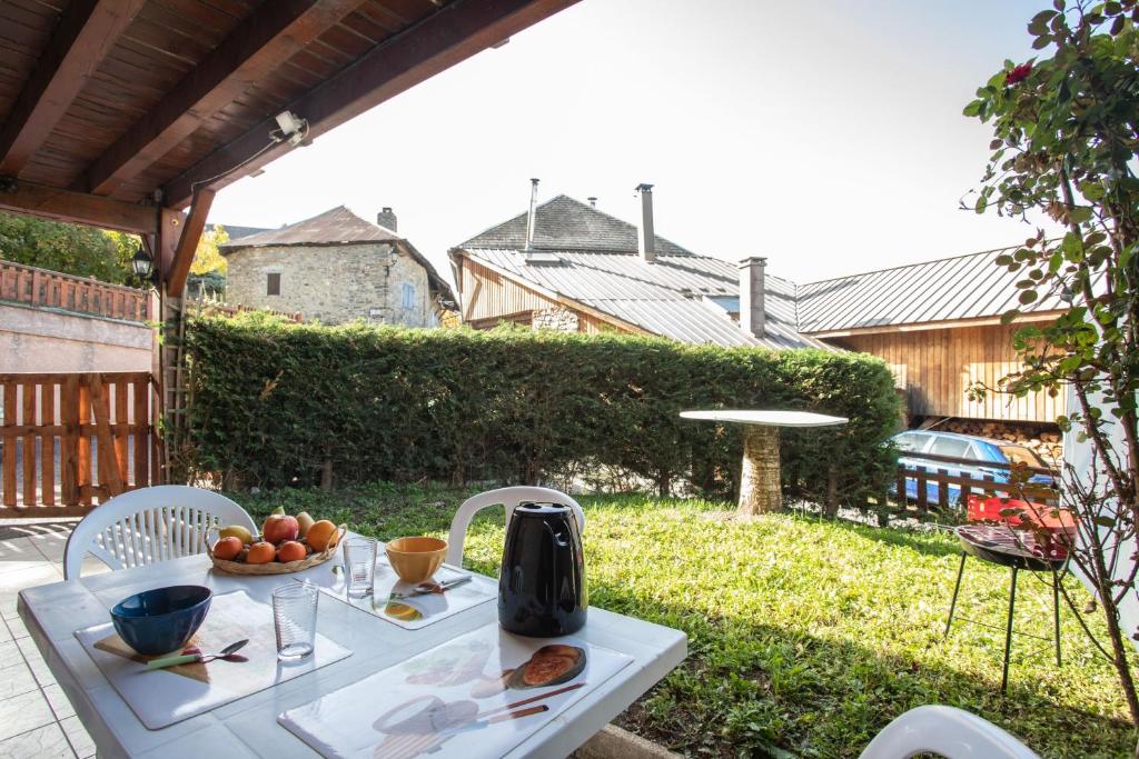 una mesa blanca con un bol de fruta en ella en La Durance - 1 chambre Terrasse et Jardin, en Saint-André-dʼEmbrun