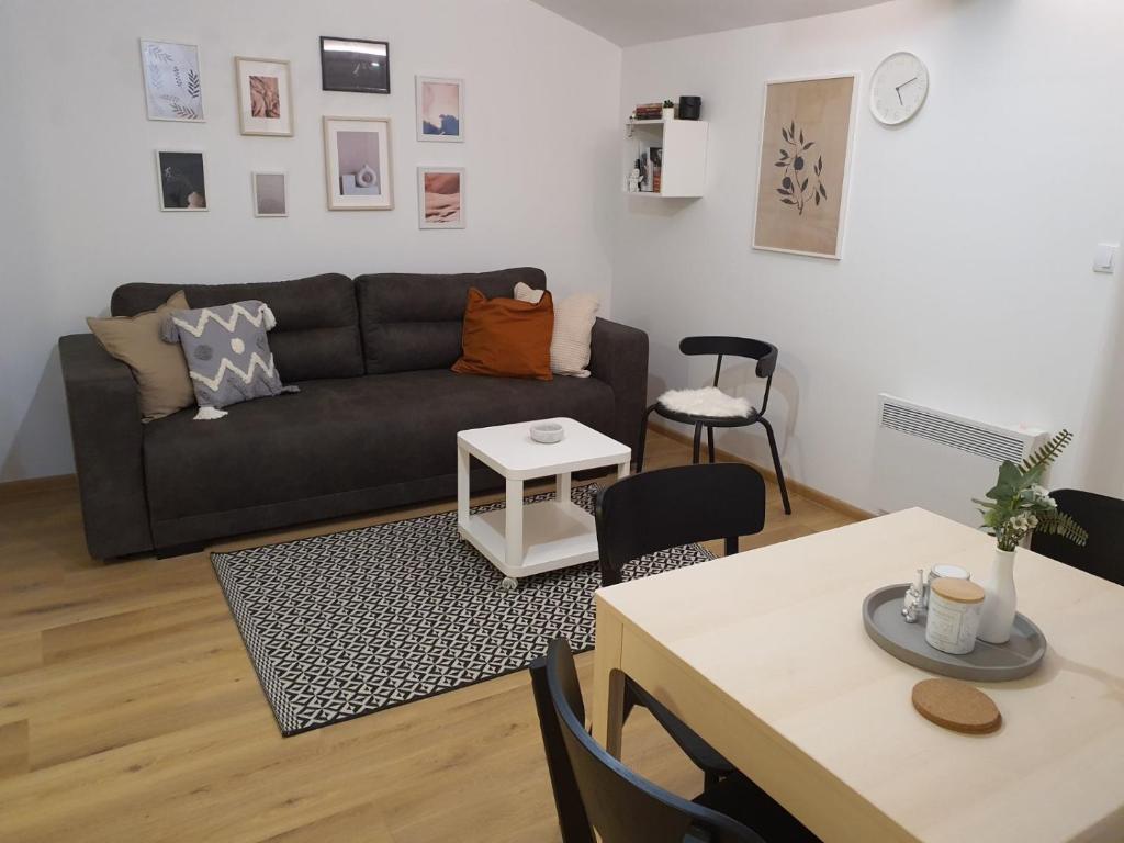 ein Wohnzimmer mit einem Sofa und einem Tisch in der Unterkunft Apartman NEDA Zlatar in Nova Varoš