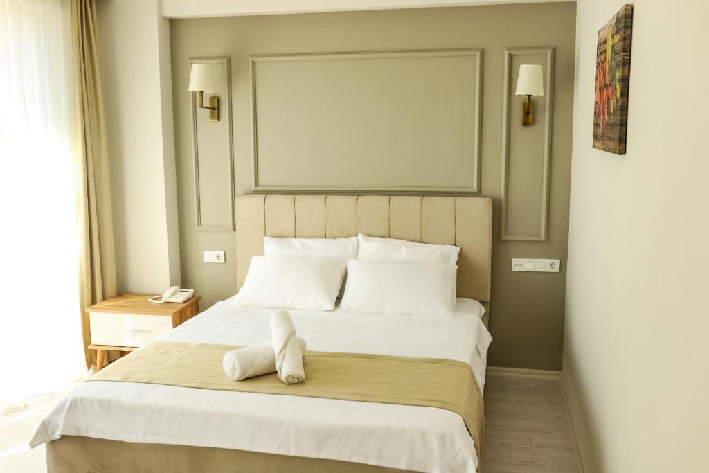 een slaapkamer met een bed met een knuffeldier erop bij PETRA HOTEL TUZLA in Tuzla
