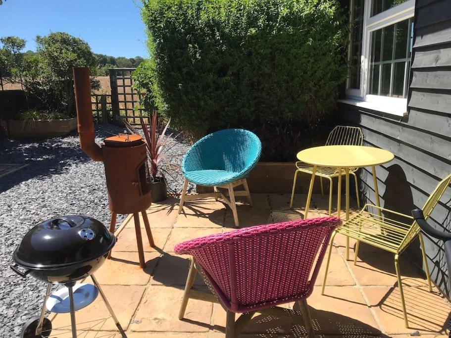 a patio with chairs and a table and a grill at The Bay Cabin, secluded retreat Freshwater Bay in Freshwater