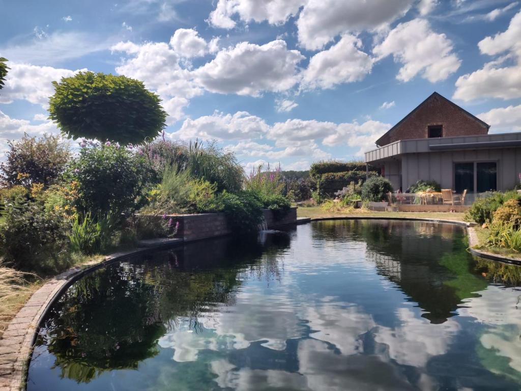 Gite avec piscine La Buissiere - Fernelmont في Pontillas: تجمع المياه امام المبنى