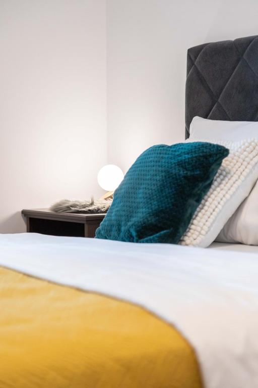 łóżko z zieloną poduszką i klawiaturą w obiekcie Design 2BDR Apartment with Balcony- FREE PARKING w Zagrzebiu