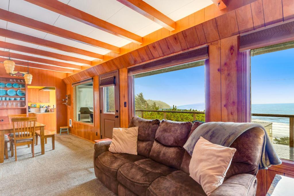 a living room with a couch and large windows at The Nook on Chinook in Tillamook