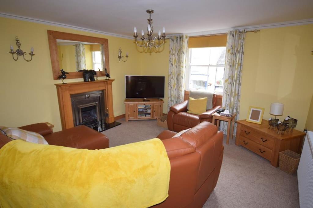 a living room with a couch and a fireplace at Ulverston Centre Superb 3 Double Bedroom Apartment in Ulverston