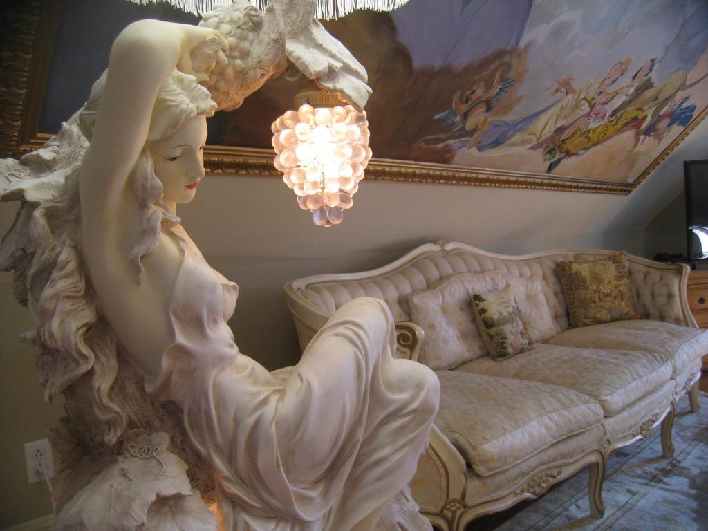 a statue of a girl in a living room with a couch at Auberge Marquis de Montcalm in Sherbrooke