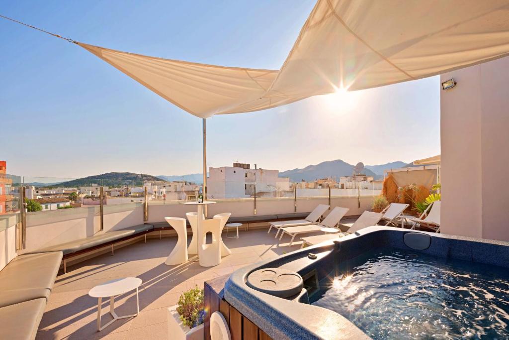 a rooftop patio with a hot tub on a roof at Mar Calma Hotel in Port de Pollensa
