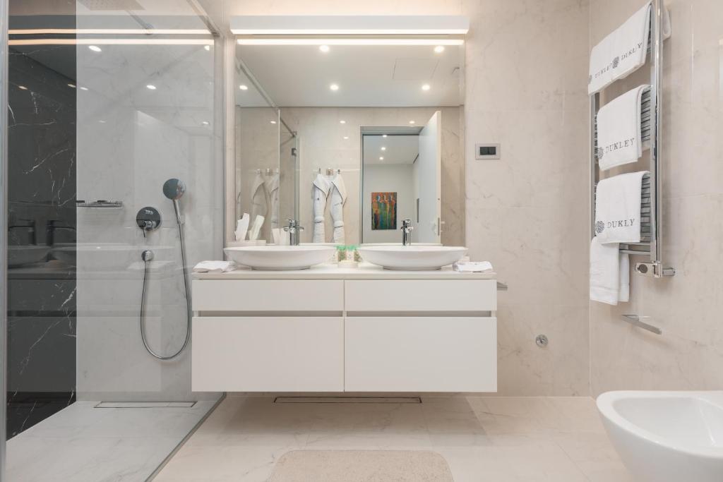 a bathroom with two sinks and a shower at Dukley Hotel & Resort in Budva