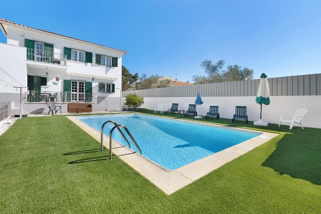 a swimming pool in the backyard of a house at Villa As Cumadres in Azeitao