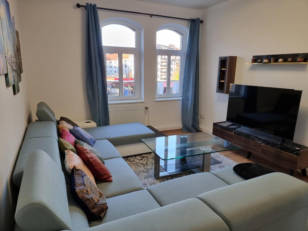 Una sala de estar con un sofá y un televisor. en Tante Emma Dubai, en Kassel