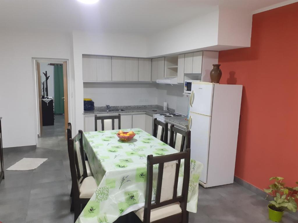 a kitchen with a table and a white refrigerator at Residencia Schneider in Junín