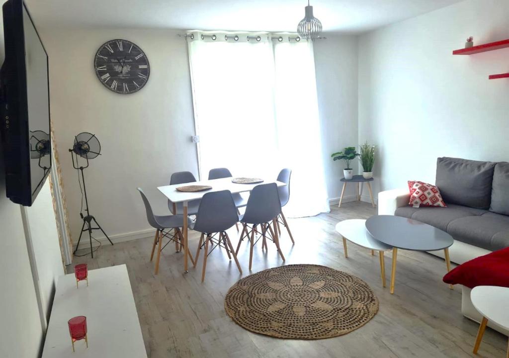 a living room with a couch and a table and chairs at Escapade Montesquieu in Perpignan