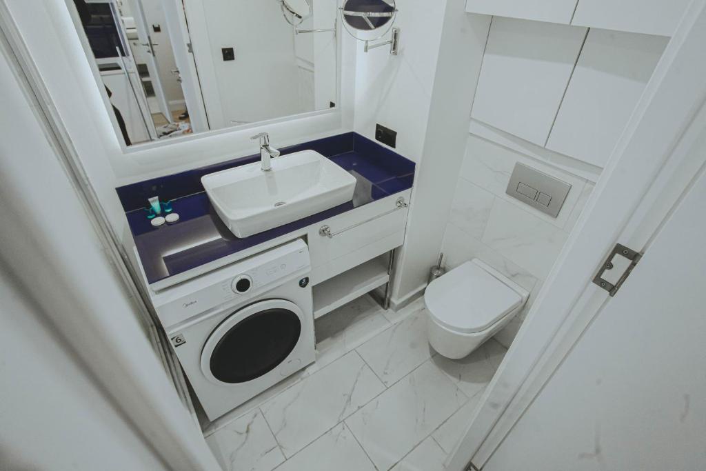 a small bathroom with a sink and a toilet at Come a Lot Aparthotel Batumi in Batumi