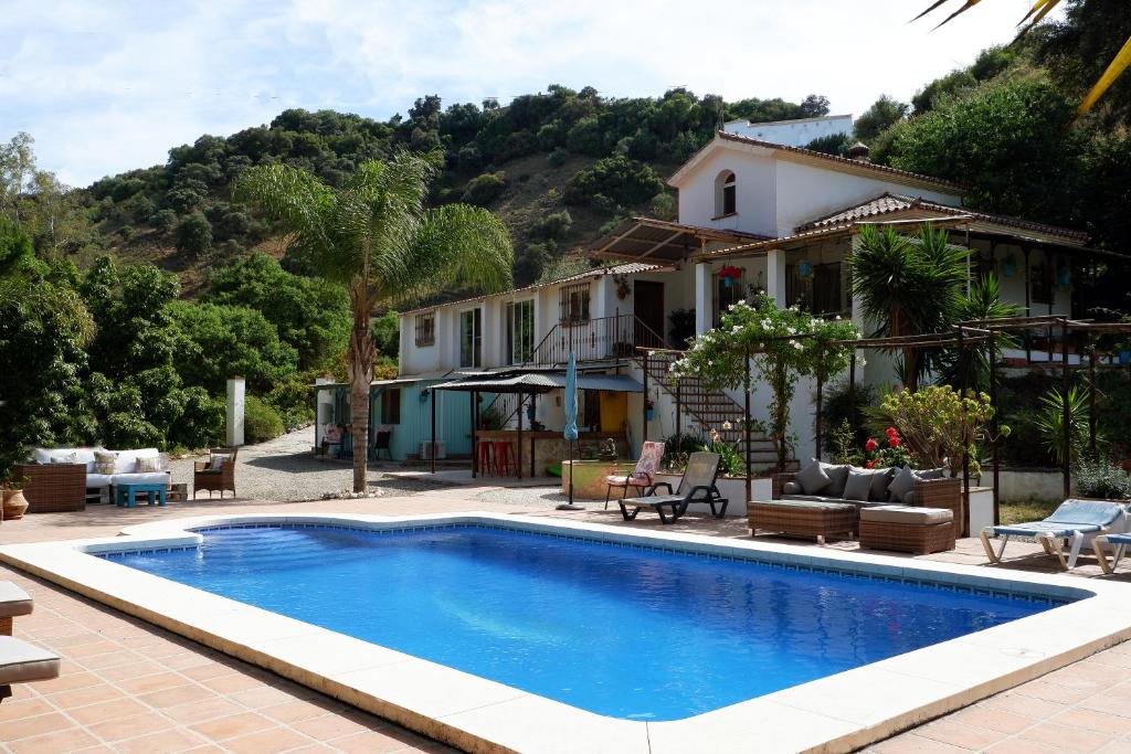 a swimming pool in front of a house at Vegan Guesthouse Finca Pereila in Coín