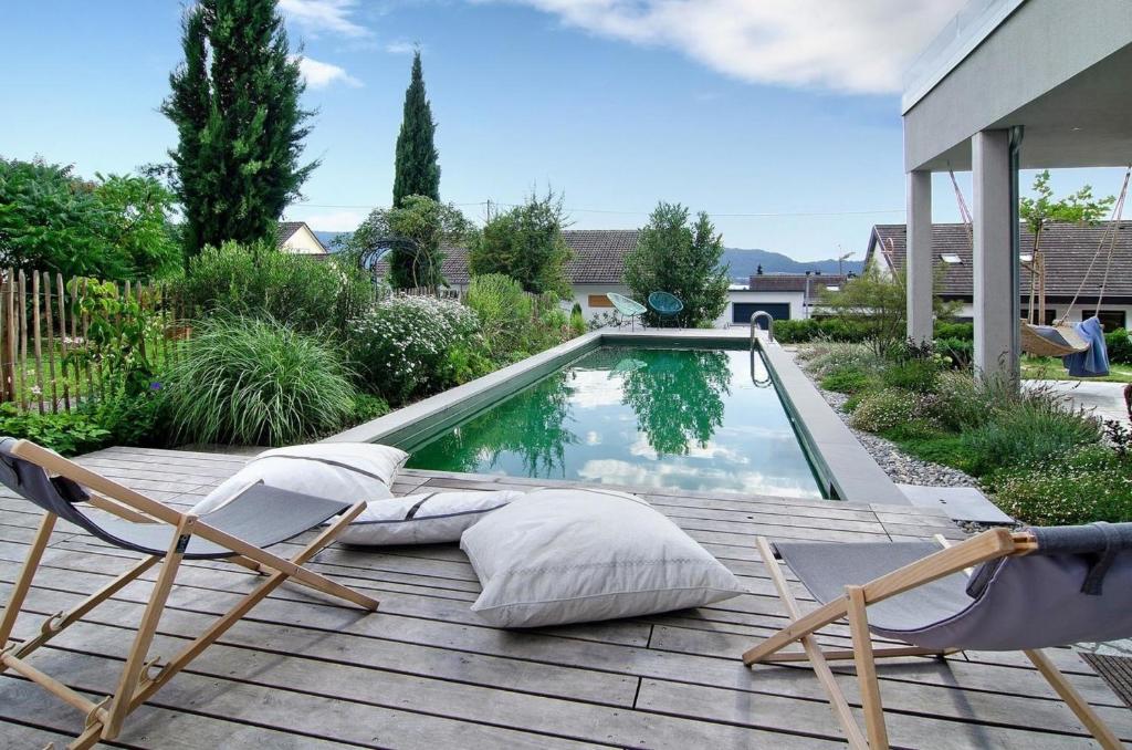 een terras met 2 stoelen en een zwembad bij Bodensee-Apartment SeeSucht No 86 in Bodman-Ludwigshafen