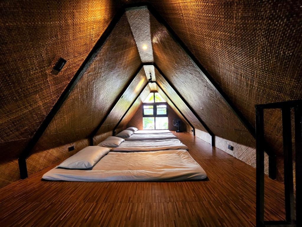 a bed room with three beds in a attic at Lake Of The Woods PH Entire Island Exclusive Glamping in Cavinti