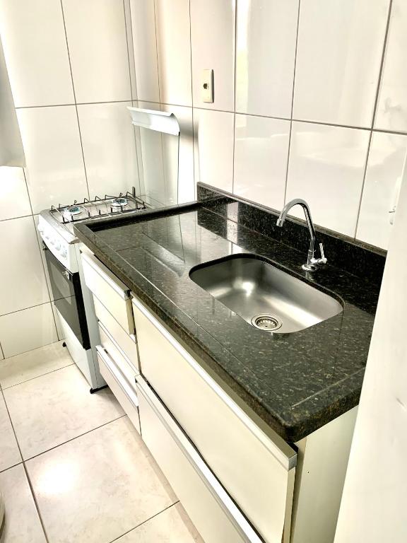 a kitchen with a sink and a stove at Flats Service BuenoAmerica in Goiânia