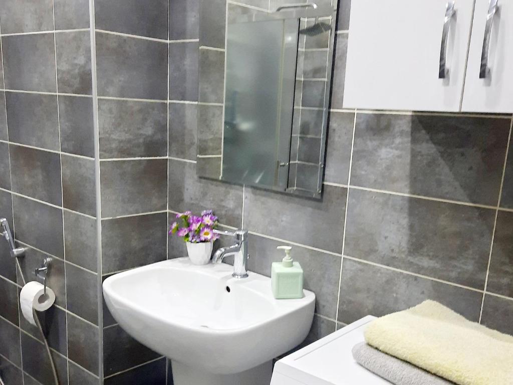 a bathroom with a sink and a mirror at Apartament - Axis palace saburtalo in Tbilisi City