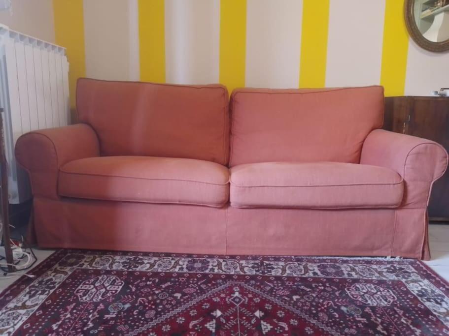 ein rotes Sofa im Wohnzimmer mit einem Teppich in der Unterkunft Mini Lambro in Mailand