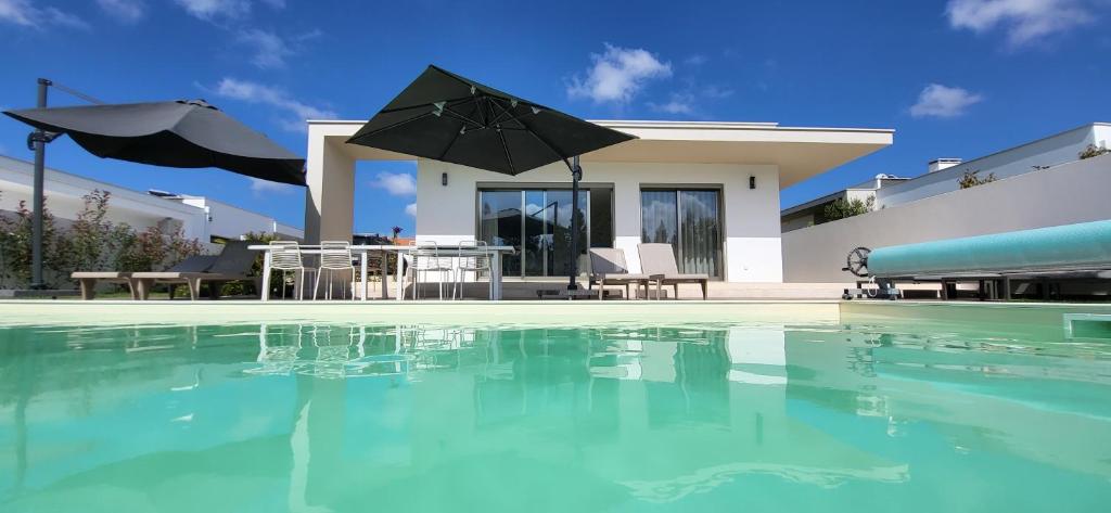 uma villa com piscina em frente a uma casa em Villa Silver Coast em Nadadouro