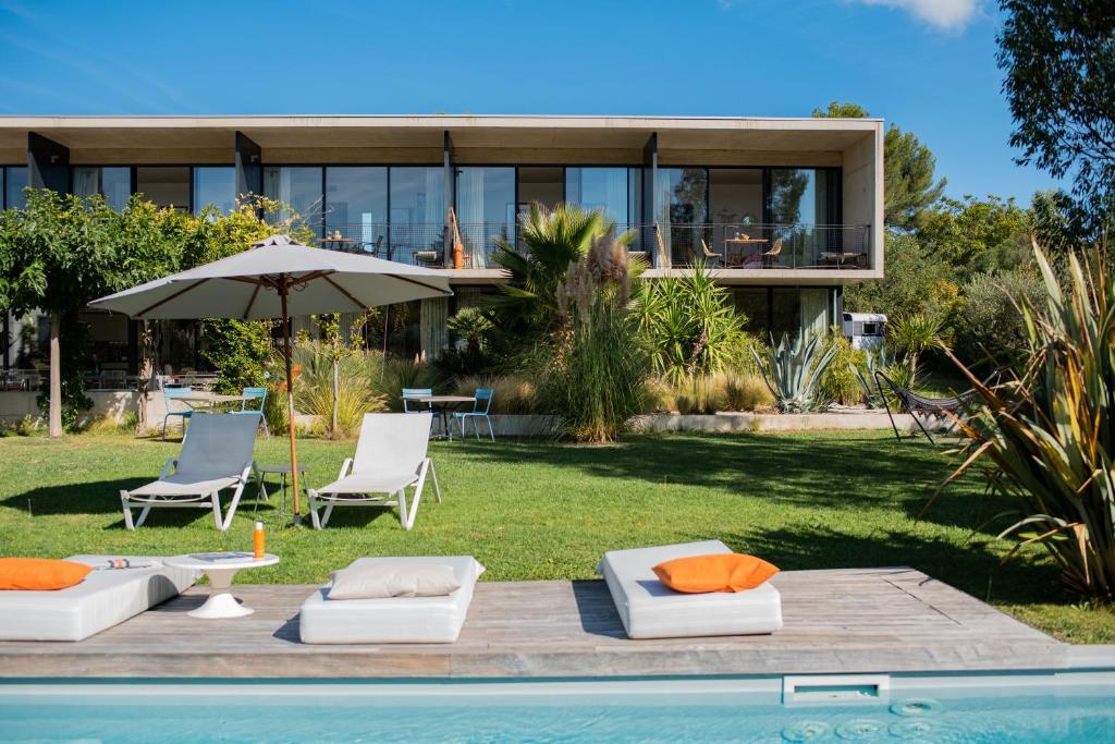 ein Haus mit einem Pool mit zwei Stühlen und einem Sonnenschirm in der Unterkunft Maison Jalon in Aix-en-Provence