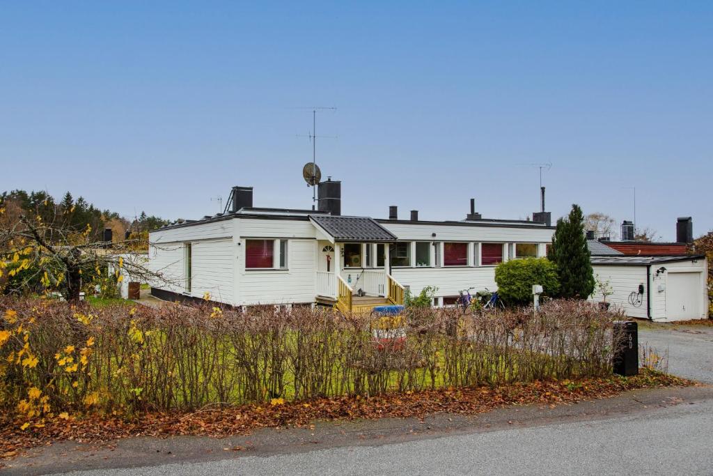 a white house sitting on the side of a road at Spacious villa in Upplands Vasby in Upplands-Väsby