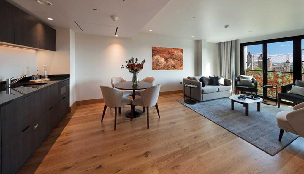 a kitchen and living room with a table and chairs at Tower Suites by Blue Orchid in London