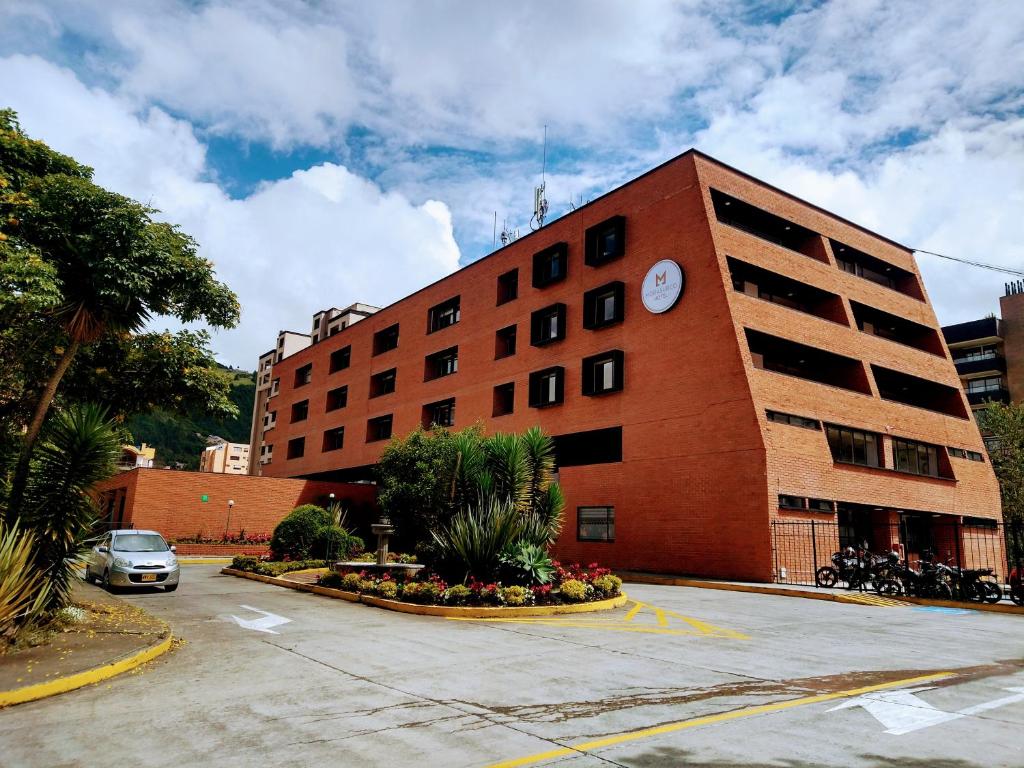 un edificio con un parcheggio di fronte di Hotel Morasurco a Pasto