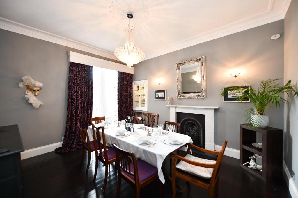 a dining room with a table and chairs and a chandelier at The Old Manse in Ayr