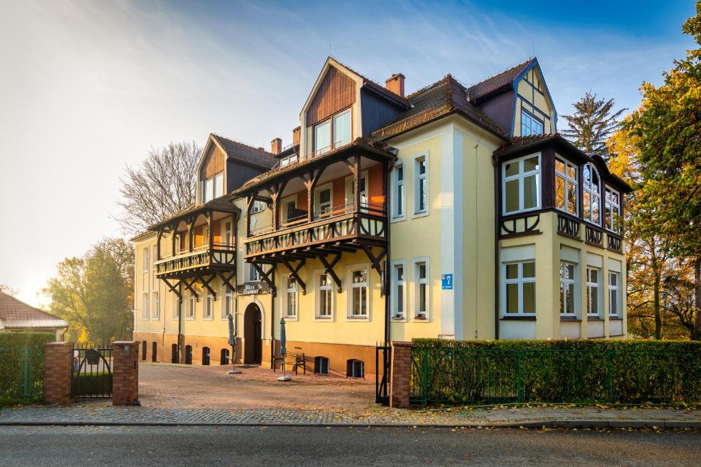 uma grande casa amarela com muitas janelas em Willa Diament em Kudowa-Zdrój