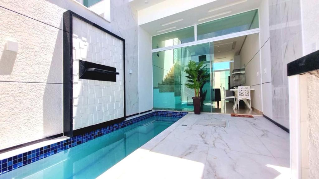 a swimming pool in the middle of a house at Apartamento a 400 metros da praia de taparapuan in Porto Seguro