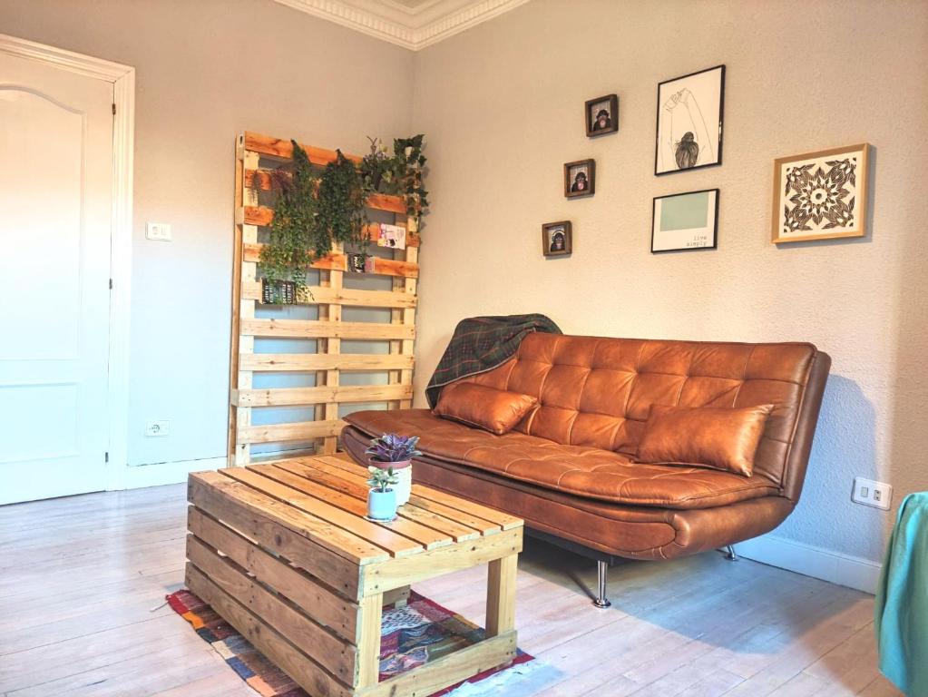 un soggiorno con divano in pelle marrone e tavolo di Apartamento Mavi a Bilbao