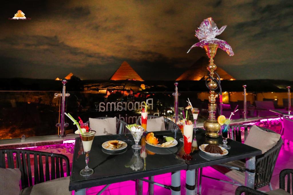 a table with food on it with a view of the pyramids at PANORAMA view pyramids in Cairo
