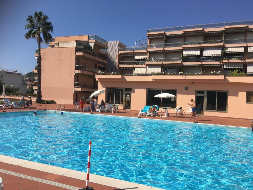 une grande piscine en face d'un bâtiment dans l'établissement Apartment in Residence BaiaSole, à Sanremo