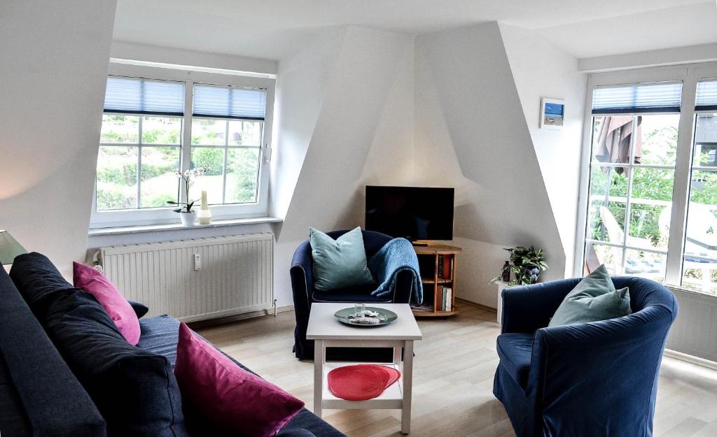 a living room with two couches and a table at Appartement Fördetraum am Strand von Wassersleben App 9 in Harrislee