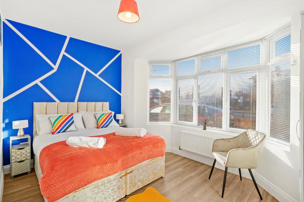 1 dormitorio con cama y pared azul en Modern 3-bed apartment with free onsite parking in Enfield, en Cheshunt