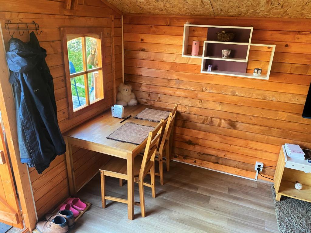 una habitación con mesa y sillas en una cabaña en Děčínska chatka en Děčín